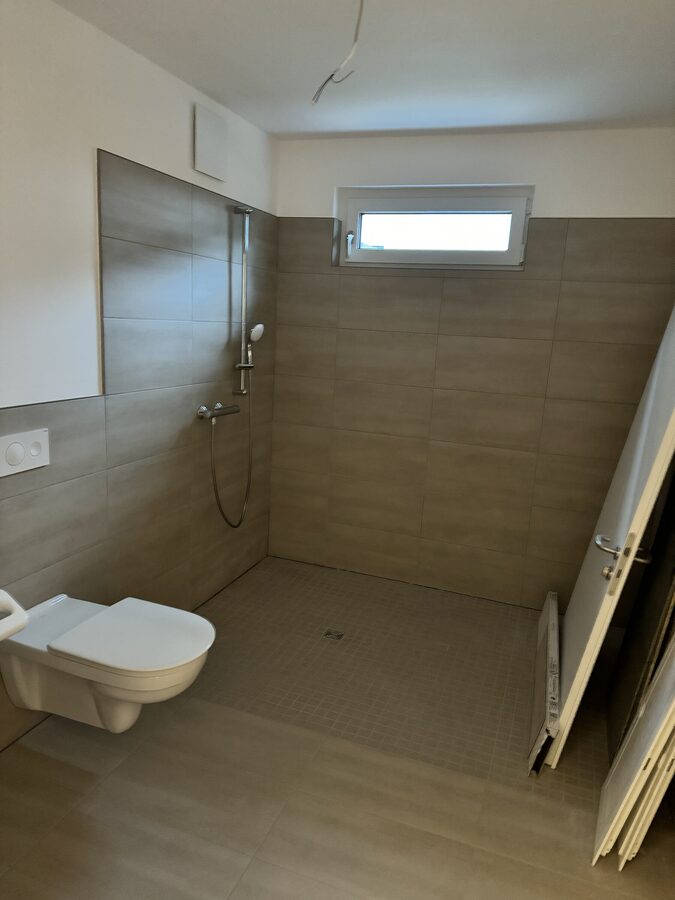 Modernes Badezimmer mit Feuchtraum-Trockenbauvorsatzschale, bodengleicher Dusche und Wandfliesen – Trockenbau Shala